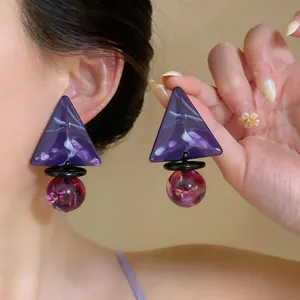Orecchini geometrici eleganti con triangoli viola marmorizzati e sfere rosa.