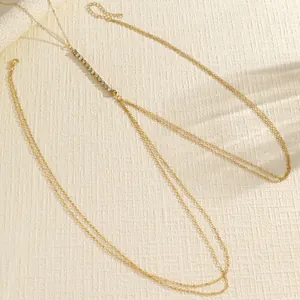 Detail view of a minimalist double-layer gold body chain with crystal rhinestone accents.
