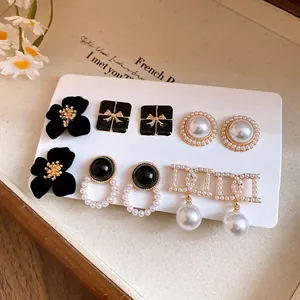 Close-up detail of vintage French style earring set with black floral and pearl studs