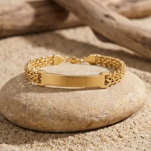 Detail view of gold stainless steel mesh bracelet with blank curved ID plate on stone.