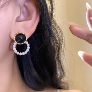 Detailed macro view of French vintage pearl earrings with elegant black gemstone detail