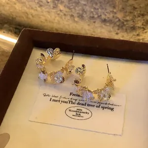Statement gold flower stud earrings with sparkling cubic zirconia stones floral design