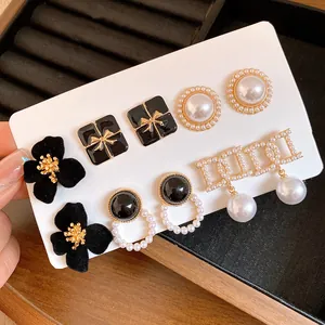 Close-up detail of French vintage pearl and black velvet earring set with gold accents