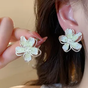 Close-up detail of elegant floral oil-drop earrings with shimmering glitter finish