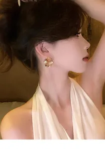 Side profile view of elegant gold crinkled flower earrings worn for a luxurious look