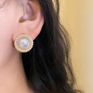 Macro view of elegant French vintage gold-halo pearl earrings on a feminine ear profile