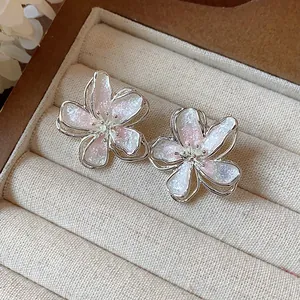 Close-up of elegant flower stud earrings with shimmering enamel petals