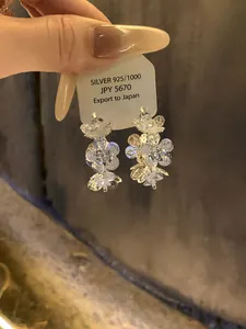 Close-up of sparkling flower-shaped zircon stud earrings on a display card