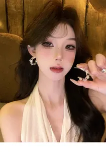 Elegant close-up shot of sparkling cubic zirconia flower earrings worn by a model.