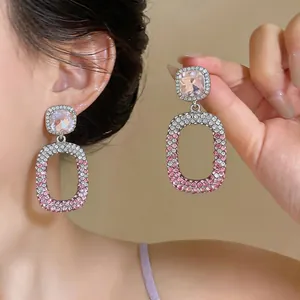 Close-up detail of luxurious pink gradient rhinestone hollow drop earrings with silver pins