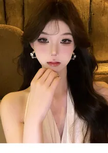Elegant Asian model wearing silver C-shaped pleated flower earrings with zircon details.