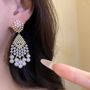 Close-up shot of elegant vintage French style pearl and zircon rhombus dangle earrings