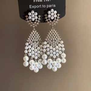 Macro view of elegant French vintage pearl drop earrings with sparkling zircon crystals