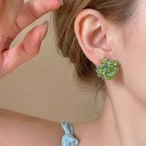 Elegant handmade green glass beaded flower stud earrings for a fresh forest-inspired look.