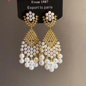 Detailed view of French retro court style gold drop earrings with pearls and zircons