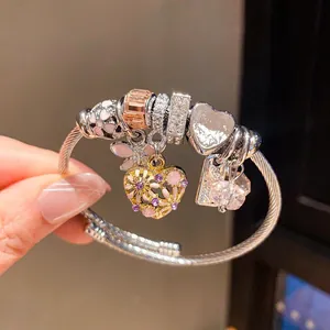Detailansicht eines Vintage-Charm-Armbands mit Herz- und Blumenanhängern