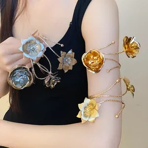 Dettaglio di bracciali da braccio in metallo con fiori oro e argento su modella
