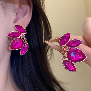 Primer plano de pendientes vintage de cristal fucsia con detalles en tono dorado