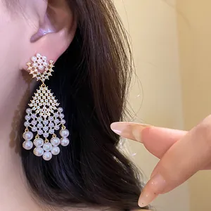 Close-up of elegant zircon and pearl chandelier earrings in vintage style