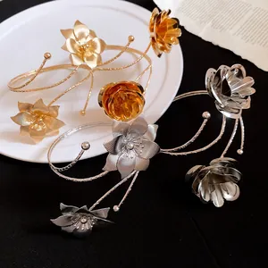 Vista dettagliata di bracciali da braccio a fiori in metallo vintage oro e argento.