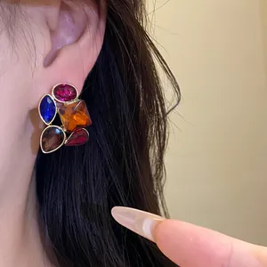 Vista detallada de pendientes vintage con piedras preciosas de colores usados en la oreja