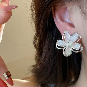 Detailed close-up view of an elegant flower stud earring with glittery white enamel finish
