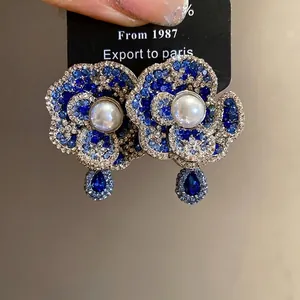 Vintage light luxury pearl rhinestone flower stud earrings with blue drop pendants.