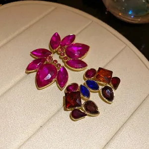 Vista detallada de pendientes vintage con cristales magenta y piedras multicolor.