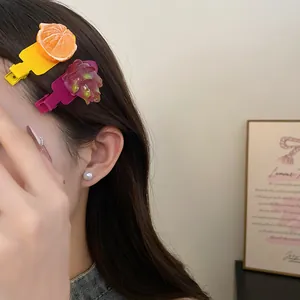 Détail de pinces à cheveux en résine en forme de fruit sur un modèle avec une boucle d'oreille