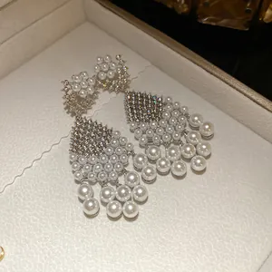 Detail view of luxury silver needle chandelier earrings with zircon and white pearls