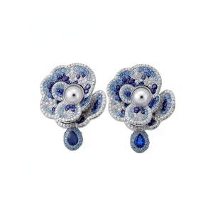 Elegant floral stud earrings with blue crystals, pearls and teardrop pendants.