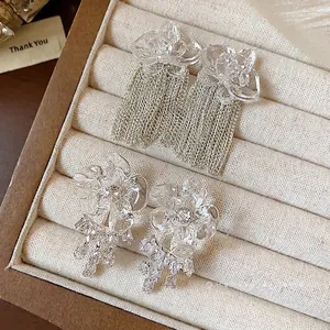 Exquisite clear resin flower earrings with shimmering tassels in a jewelry box.