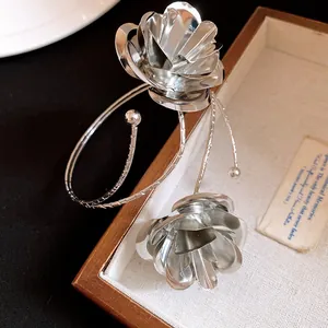 Primo piano di un bracciale vintage in argento con due motivi a fiori di rosa a strati