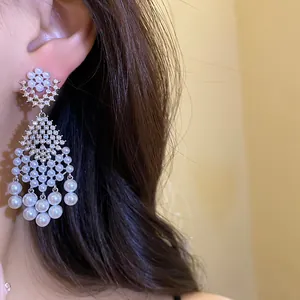 Detail shot of French retro chandelier earrings with zircons and pearls on an Asian model.