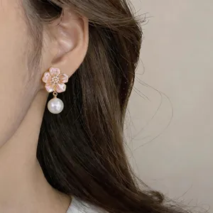 Close-up detail of vintage style floral earring with elegant hanging pearl pendant