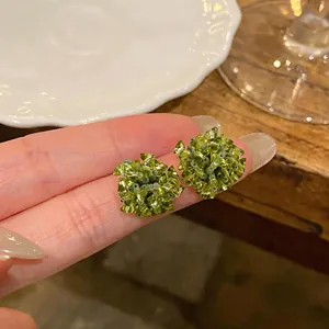 Macro view of green glass beaded floral stud earrings with s925 silver needles
