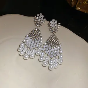 Detailed view of French retro chandelier earrings with white pearls and zircons