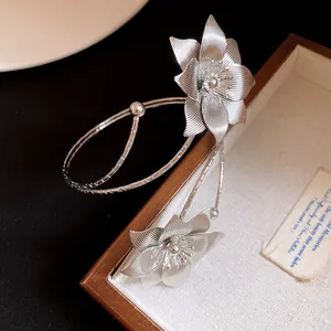 Dettaglio di fiori in metallo argentato testurizzato su un bracciale in stile vintage