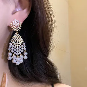 Close-up of French retro court style pearl and zircon drop earrings worn on ear