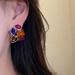 Elegante primer plano de un pendiente vintage con cristales de colores usado en la oreja