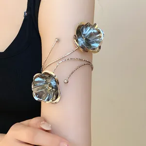 Dettaglio di un bracciale vintage in metallo argentato con motivi floreali testurizzati.
