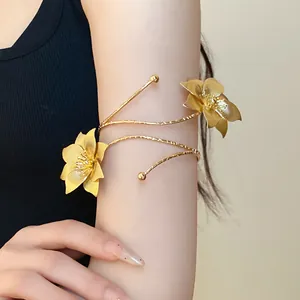 Vista dettagliata di un bracciale da braccio a fiore dorato con trama in metallo