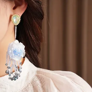 Exquisite Ohrringe mit blauen Harzblumen und Quasten am Modell