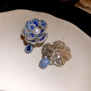 Detailed close-up view of pearl and blue crystal flower earrings showing fine craftsmanship