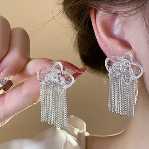 Detailed close-up of resin flower tassel earrings with shimmering silver chain elements