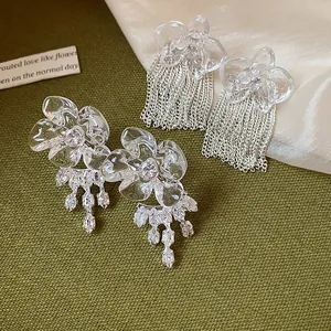 Detail view of elegant resin flower earrings with silver tassels and zircon dangles.