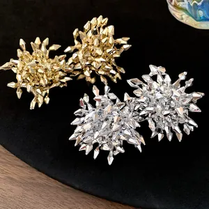 Dettaglio macro di eleganti orecchini a lobo a fiore sfaccettati in oro e argento