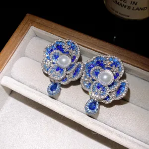 Detailed macro shot of vintage flower earrings with blue crystals and central pearl