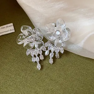 Macro view of crystal flower earrings with sparkling zircon tassels and resin petals