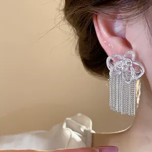 Close-up detail of exquisite resin flower earrings featuring delicate silver chain tassels